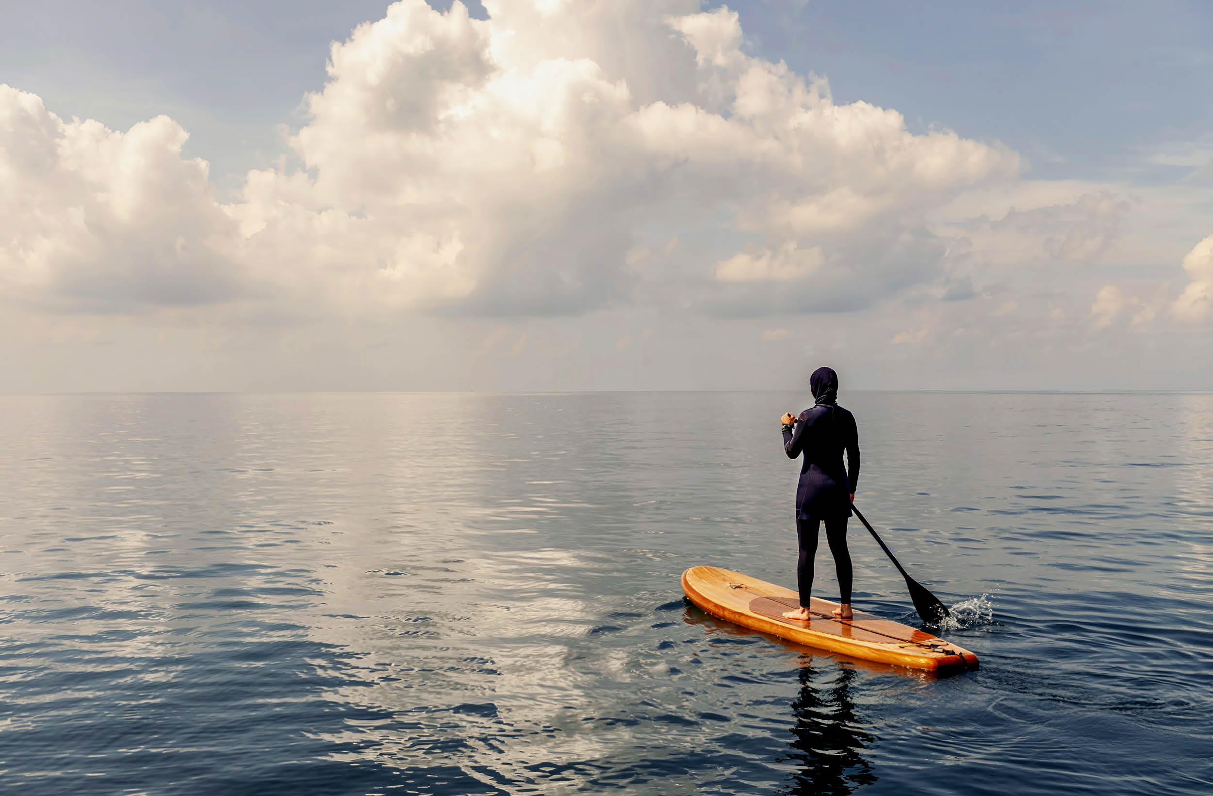 Person standing on paddle board floating on the ocean